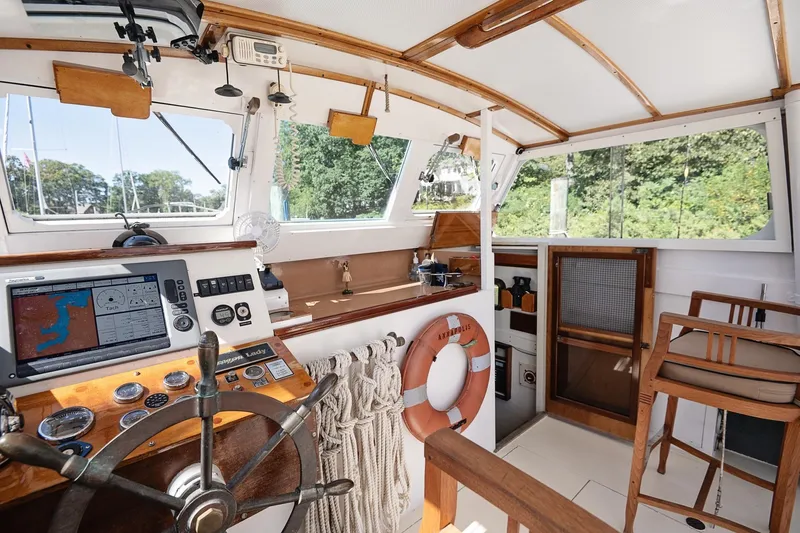 Slide: The Image of 1972 Jarvis Newman Downeast boat interior with steering wheel, navigation equipment, and wooden seating. - 18