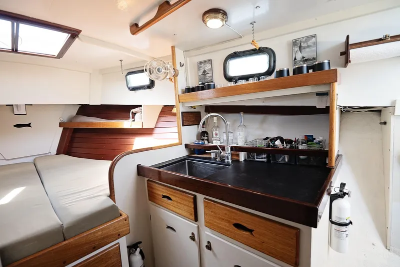 Slide: The Image of 1972 Jarvis Newman Downeast boat interior with kitchenette, bed, and wooden accents. - 21