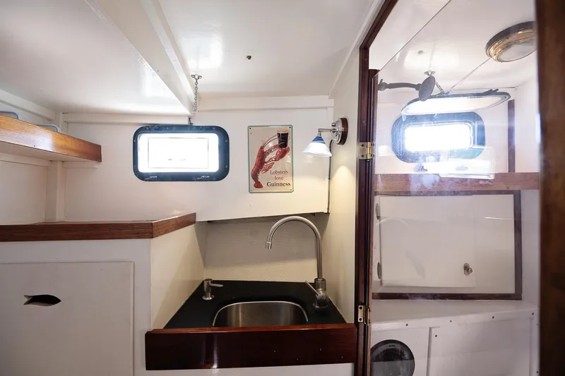Slide: The Image of 1972 Jarvis Newman Downeast boat interior with sink, portholes, and vintage decor. - 25