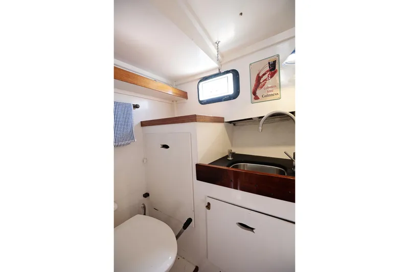 Slide: The Image of 1972 Jarvis Newman Downeast boat interior with sink, toilet, and lobster-themed decor. - 26