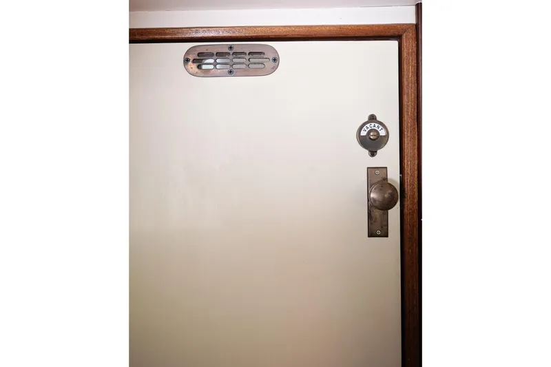 Slide: The Image of 1972 Jarvis Newman Downeast boat door with vintage handle and "Vacant" indicator. - 27