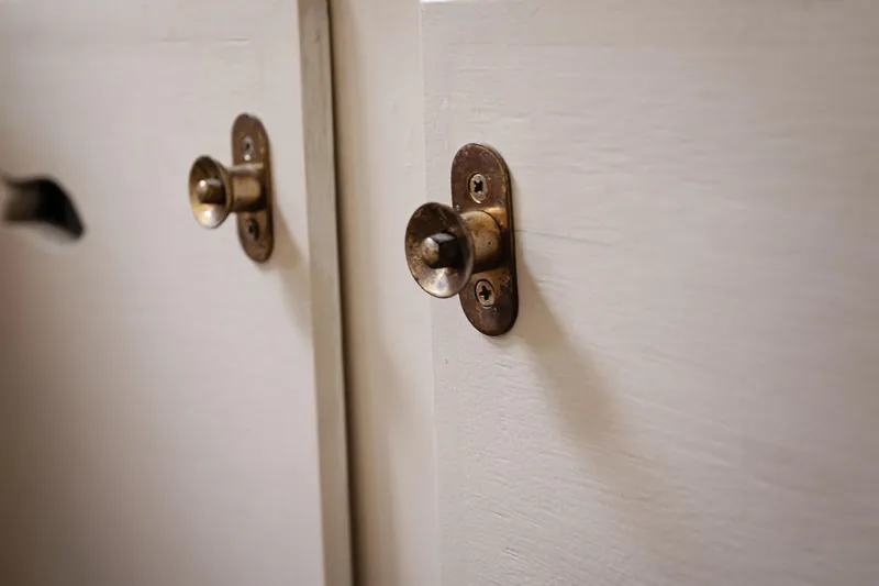 Slide: The Image of Close-up of vintage brass cabinet knobs on a 1972 Jarvis Newman Downeast boat. - 28