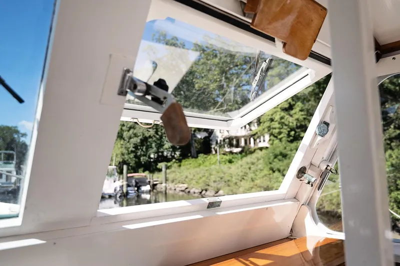 Slide: The Image of Interior view of a 1972 Jarvis Newman Downeast boat window, overlooking a serene waterfront. - 9