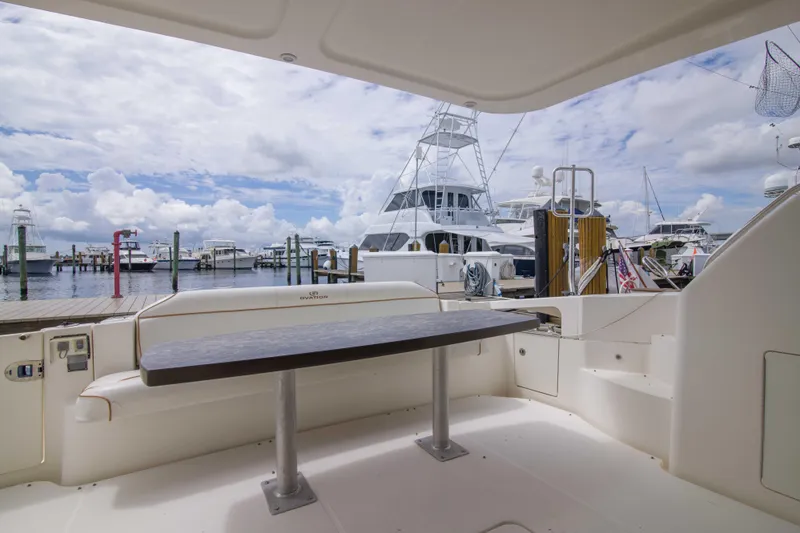 Slide: The Image of 2009 Silverton Oviation 52 yacht interior with marina view, featuring a sleek table and seating area. - 22