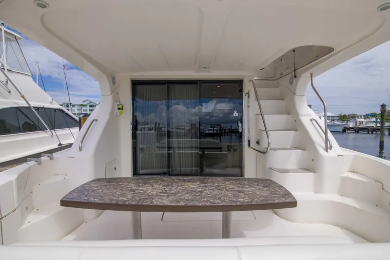 Slide: The Image of 2009 Silverton Oviation 52 yacht interior with table and stairs, docked at marina. - 24