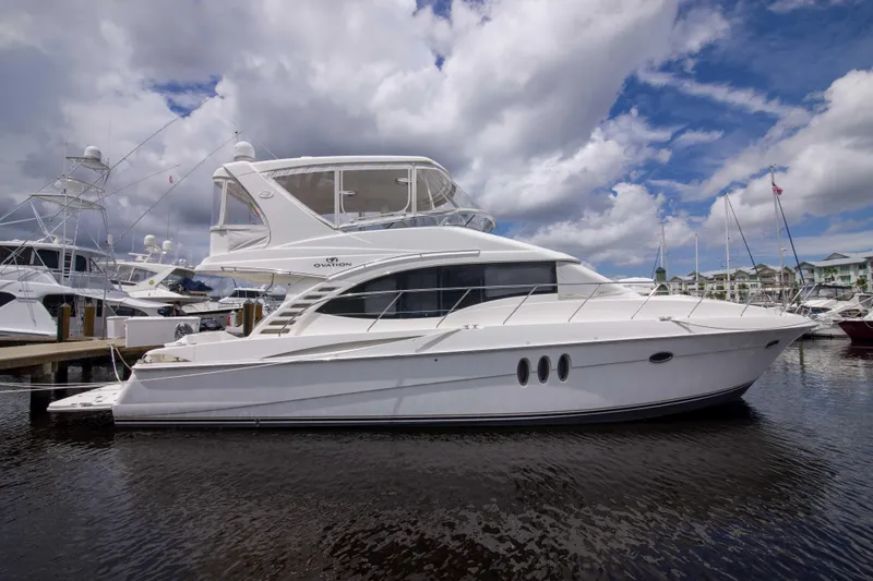 Slide: The Image of 2009 Silverton Oviation 52 yacht docked at marina under cloudy sky. - 3