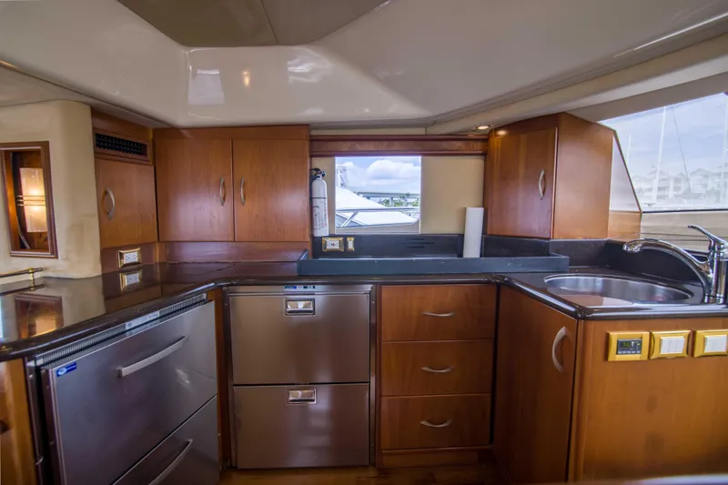 Slide: The Image of Luxurious kitchen interior of 2009 Silverton Oviation 52 yacht with modern appliances and wood cabinetry. - 40