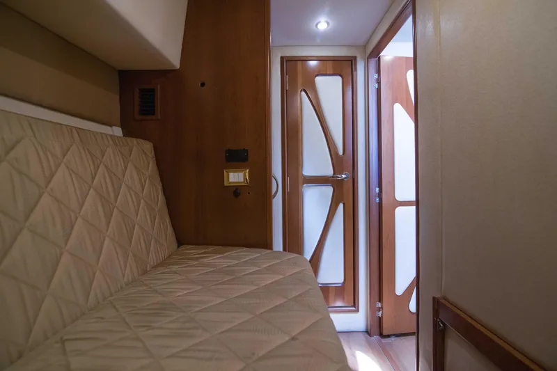 Slide: The Image of Interior of 2009 Silverton Oviation 52 yacht with quilted seating and modern wooden door. - 47