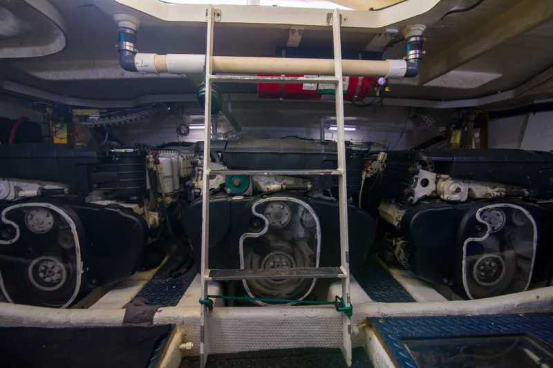 Slide: The Image of Engine room of 2009 Silverton Oviation 52 yacht, featuring dual engines and a central ladder. - 56