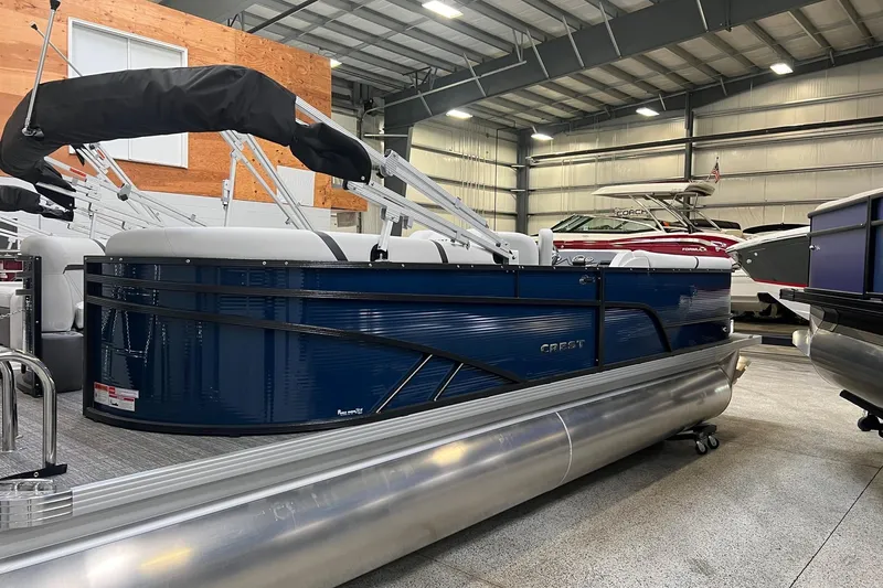 The Image of 2023 Crest LX 240 SLC pontoon boat in showroom, blue exterior, modern design. - 1
