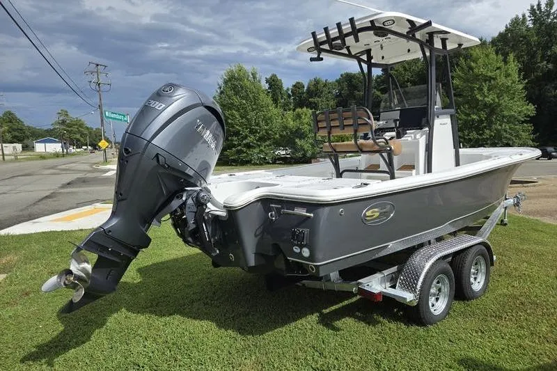 Slide: The Image of 2026 Sea Hunt BX 22 BR boat on trailer, parked on grass, with Yamaha outboard motor. - 2