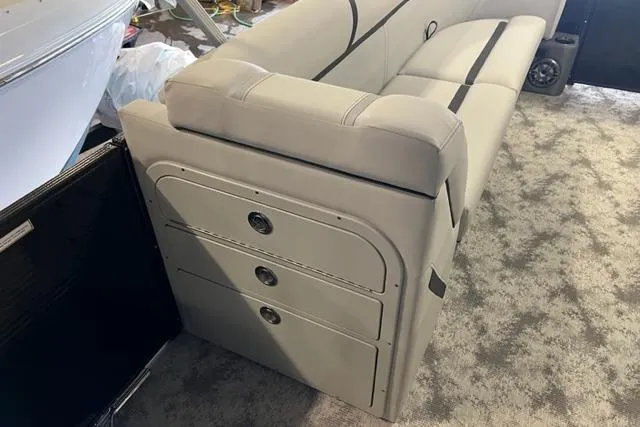 Slide: The Image of 2023 Crest LX 240SLSC boat interior with beige seating and storage compartments. - 5