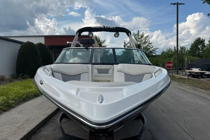 Slide: The Image of 2014 MasterCraft X-5 boat with sleek design, parked outdoors under a cloudy sky. - 5
