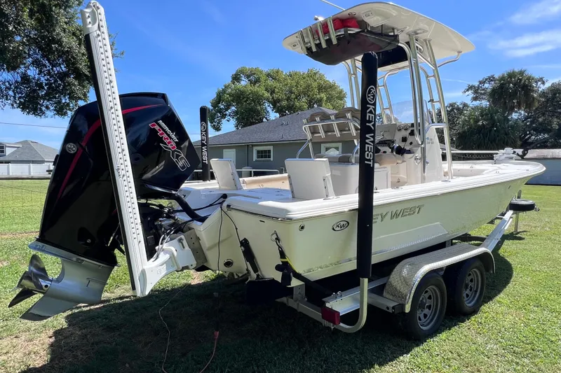 The Image of 2020 Key West 230 Bay Reef boat on trailer, featuring powerful outboard motor. - 0