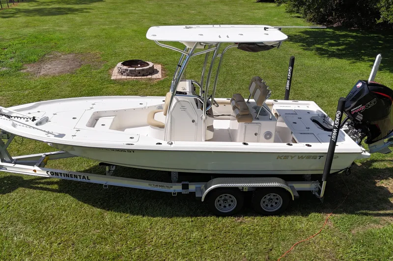 Slide: The Image of 2020 Key West 230 Bay Reef boat on trailer, parked on grass. - 1