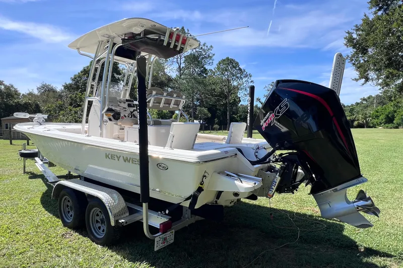 Slide: The Image of 2020 Key West 230 Bay Reef boat on trailer, featuring powerful outboard motor. - 10