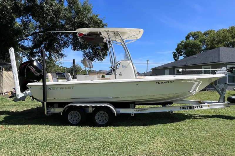 Slide: The Image of 2020 Key West 230 Bay Reef boat on trailer, parked on grass. - 12