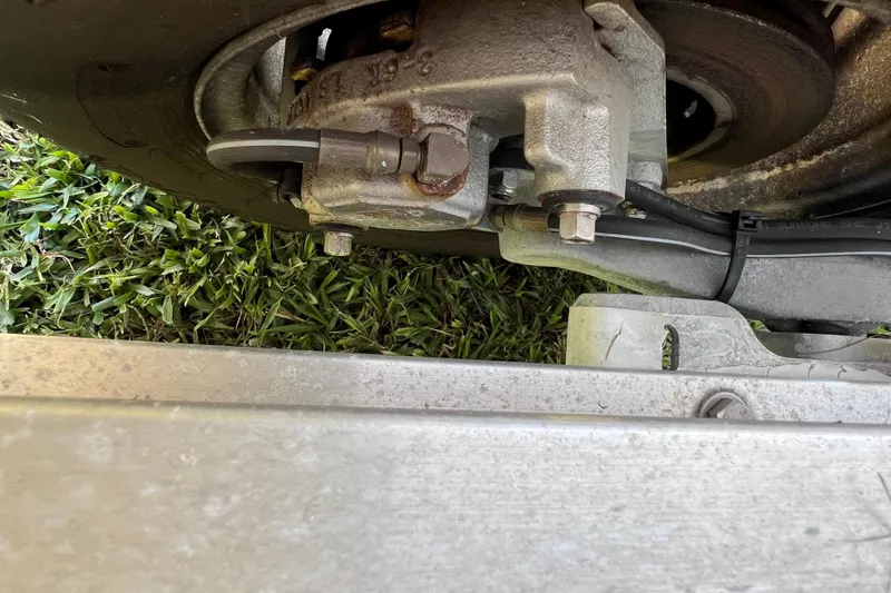 Slide: The Image of Close-up of a 2020 Key West 230 Bay Reef trailer wheel and brake system on grass. - 16