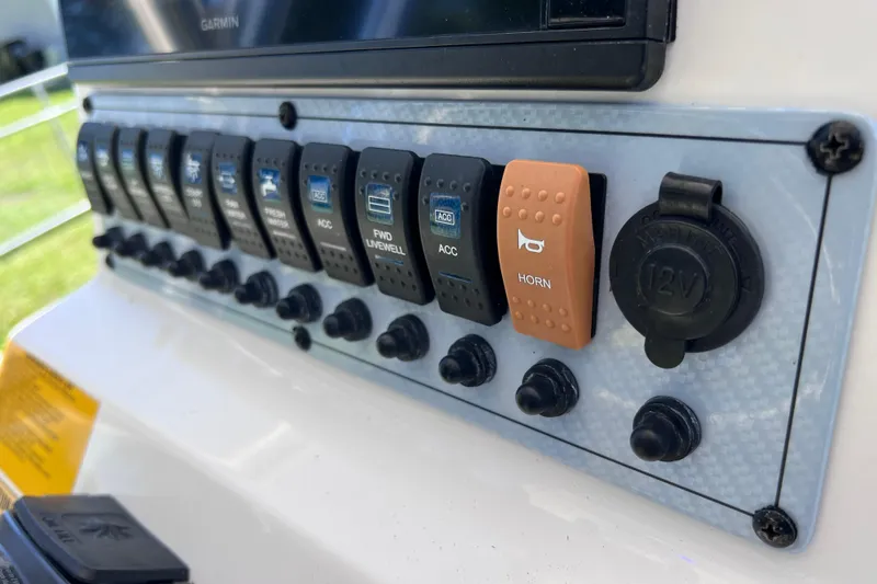 Slide: The Image of Control panel of a 2020 Key West 230 Bay Reef boat with labeled switches. - 55