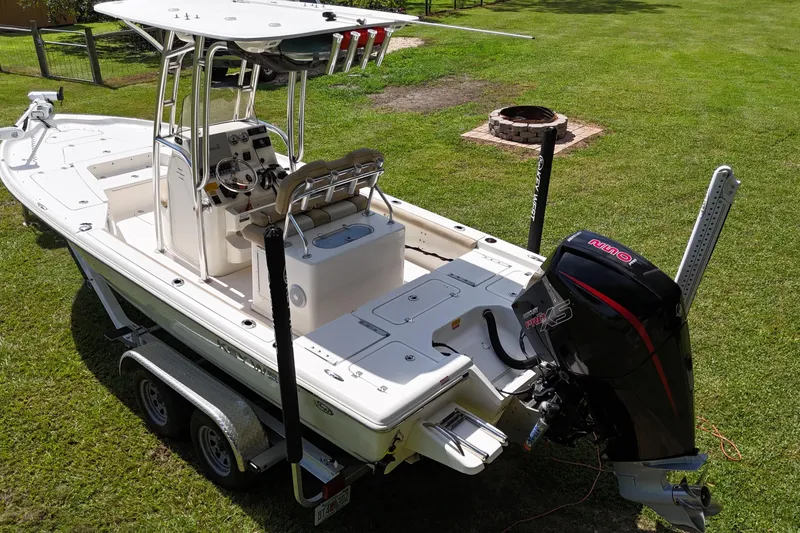Slide: The Image of 2020 Key West 230 Bay Reef boat on trailer, parked on grass, with outboard motor. - 6