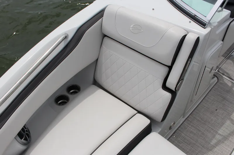 Slide: The Image of 2023 Crownline E235 boat interior with white cushioned seating and cup holders. - 10
