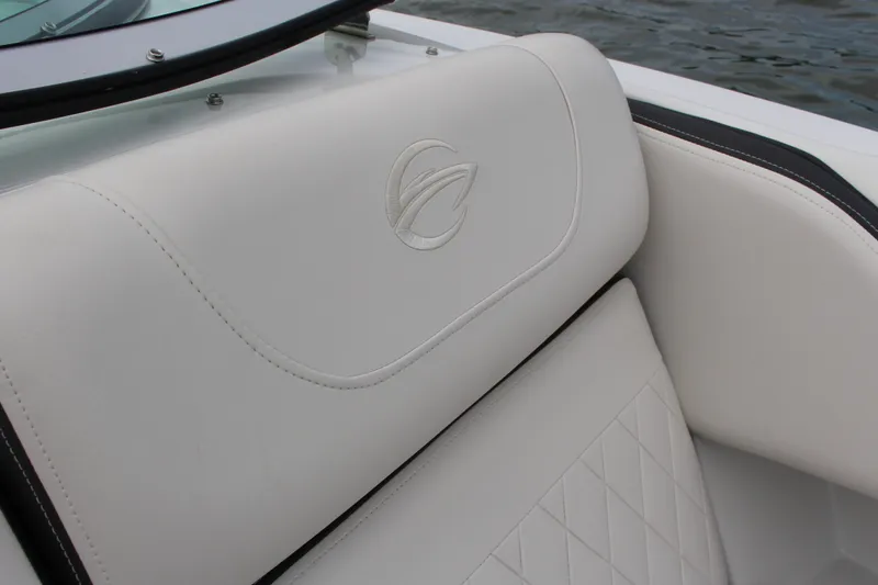 Slide: The Image of 2023 Crownline E235 boat seat with logo, featuring white upholstery and diamond stitching. - 13