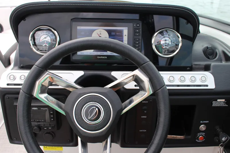 Slide: The Image of 2023 Crownline E235 boat dashboard with steering wheel and Garmin navigation system. - 16