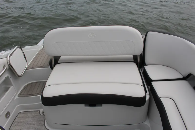 Slide: The Image of 2023 Crownline E235 boat interior with white cushioned seating by the water. - 19