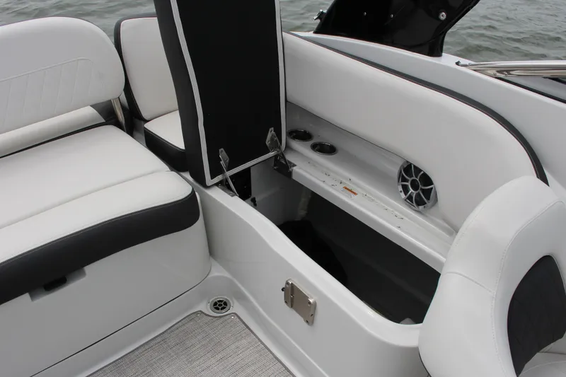 Slide: The Image of 2023 Crownline E235 boat interior with open storage compartment and seating. - 2