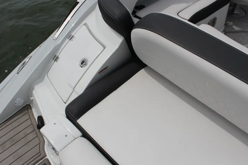 Slide: The Image of 2023 Crownline E235 boat interior with sleek seating and storage compartment. - 23