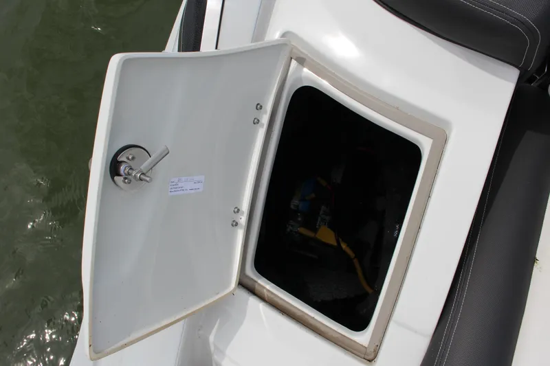 Slide: The Image of Open storage compartment on 2023 Crownline E235 boat, showing interior details. - 24