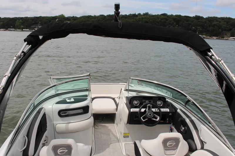 Slide: The Image of 2023 Crownline E235 boat interior with steering wheel, seating, and lake view. - 26