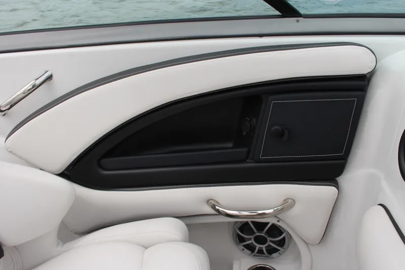 Slide: The Image of 2023 Crownline E235 boat interior with white and black seating, chrome handle, and speaker. - 5