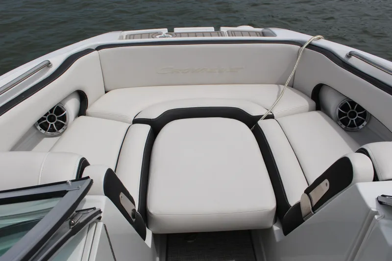 Slide: The Image of 2023 Crownline E235 boat interior with white cushioned seating and speakers. - 7