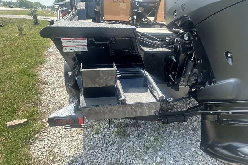 Slide: The Image of 2026 SeaArk EasyCat boat with open storage compartments on gravel surface. - 10