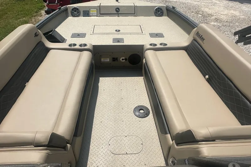 Slide: The Image of 2026 SeaArk EasyCat boat interior with beige seating and cup holders. - 2