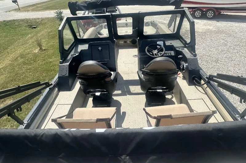 Slide: The Image of 2026 SeaArk EasyCat boat interior with dual seats and steering wheel, parked on gravel. - 6