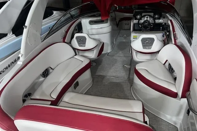 Slide: The Image of 2023 Crownline E255 boat interior with red and white seating, modern dashboard, and spacious layout. - 5