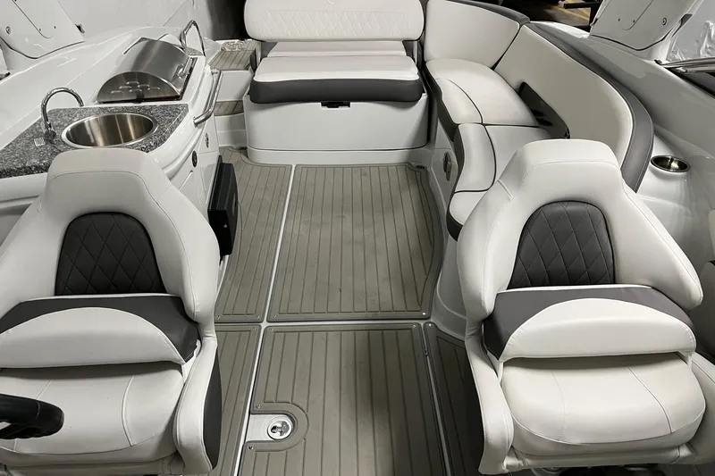 Slide: The Image of 2023 Crownline E285 boat interior with luxurious seating and kitchenette. - 11
