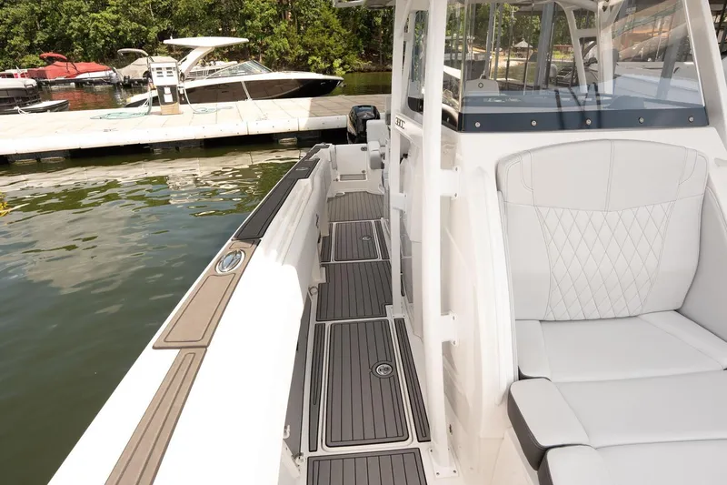Slide: The Image of 2018 Fountain 38 SCX boat interior with sleek seating and dock view. - 18