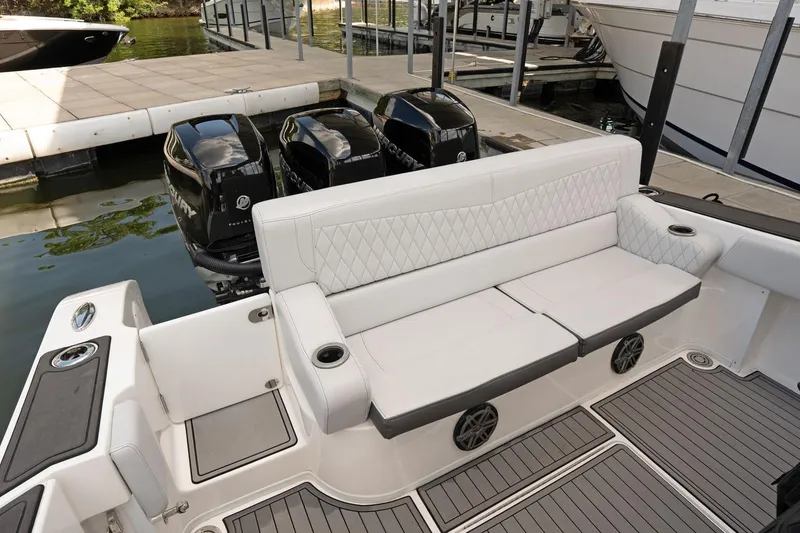 Slide: The Image of 2018 Fountain 38 SCX boat with white seating and triple outboard engines at dock. - 20