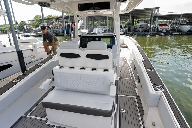 Slide: The Image of 2018 Fountain 38 SCX boat interior with seating and dashboard, docked at marina. - 22