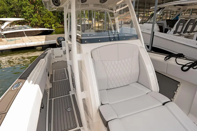 Slide: The Image of 2018 Fountain 38 SCX boat interior with white seating and sleek design at a marina. - 25
