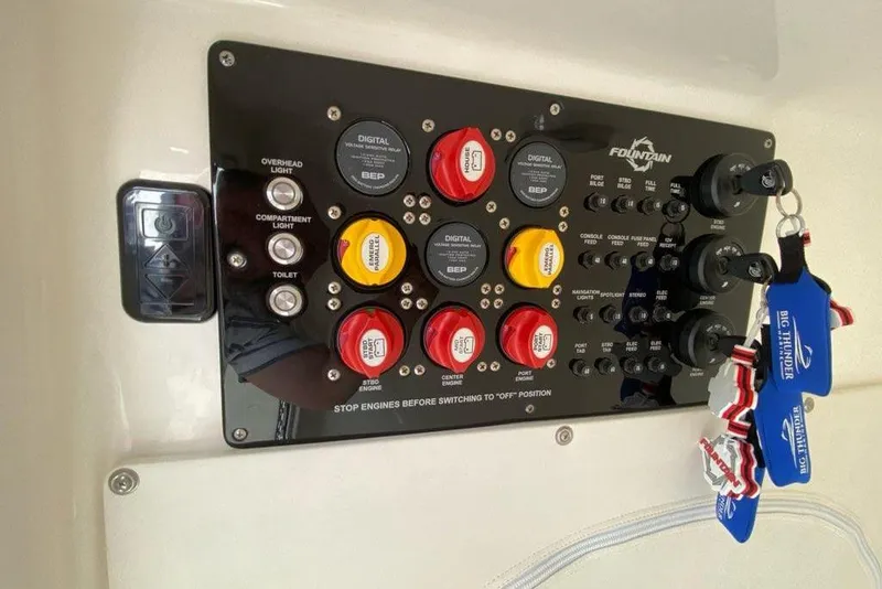 Slide: The Image of Control panel of a 2018 Fountain 38 SCX boat with switches and keychains. - 29