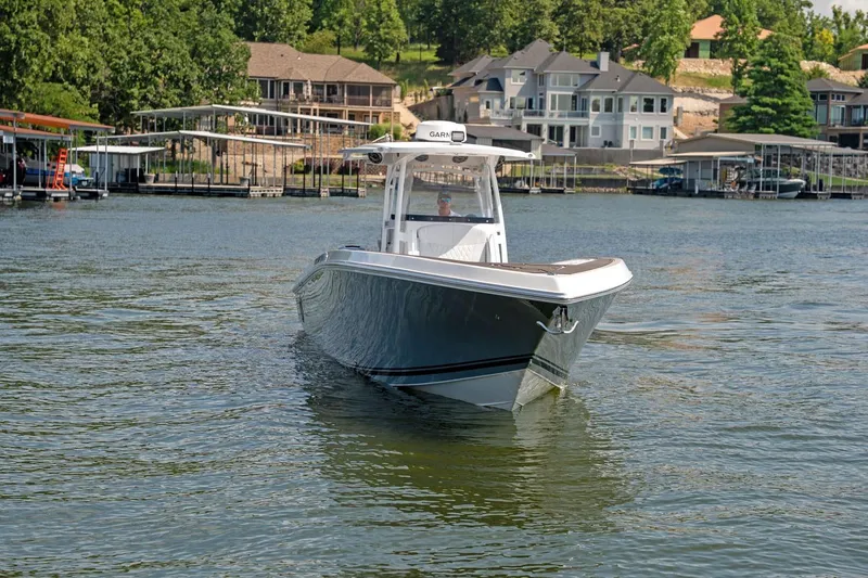 Slide: The Image of 2018 Fountain 38 SCX boat cruising on a scenic lake near waterfront homes. - 3