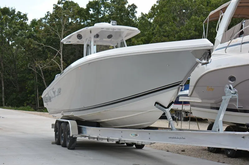 Slide: The Image of 2018 Fountain 38 SCX boat on trailer, parked outdoors near trees. - 31