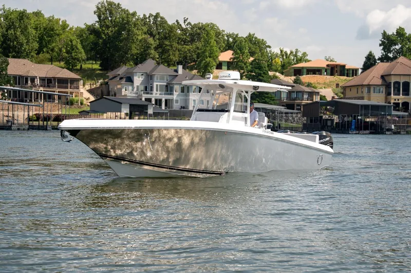 Slide: The Image of 2018 Fountain 38 SCX boat cruising on a lake near luxury waterfront homes. - 5