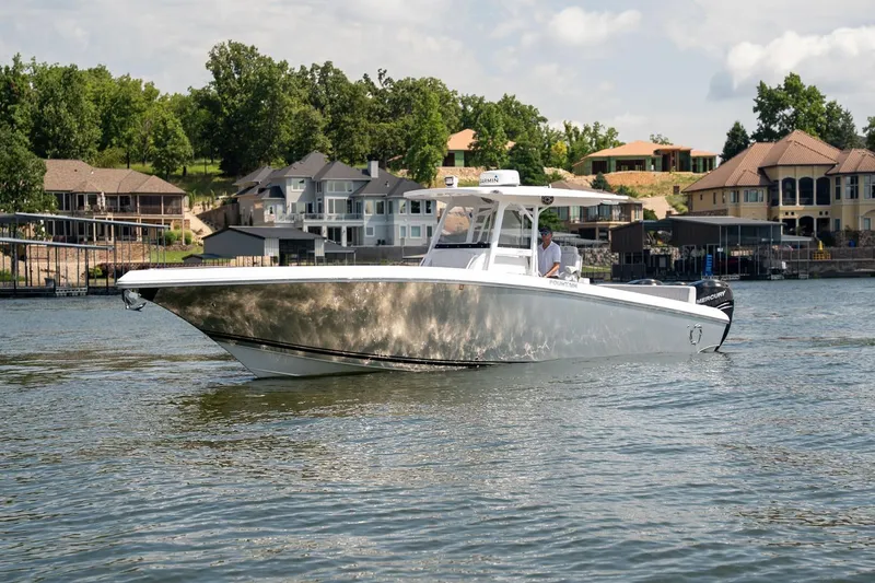Slide: The Image of 2018 Fountain 38 SCX boat cruising on a scenic lake near luxury homes. - 6