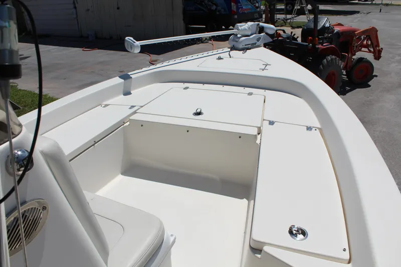Slide: The Image of 2015 Pathfinder 2200 boat interior with storage compartments and seating, parked near a tractor. - 17