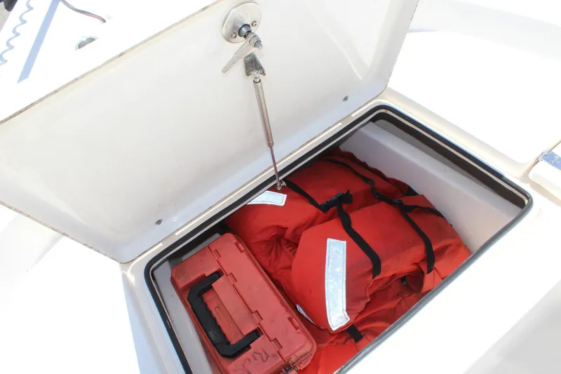 Slide: The Image of Open storage compartment on 2015 Pathfinder 2200 boat with life jackets and a red toolbox. - 18
